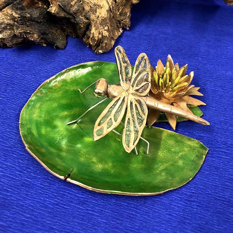 Dragonfly on a flat lily leaf made in metal